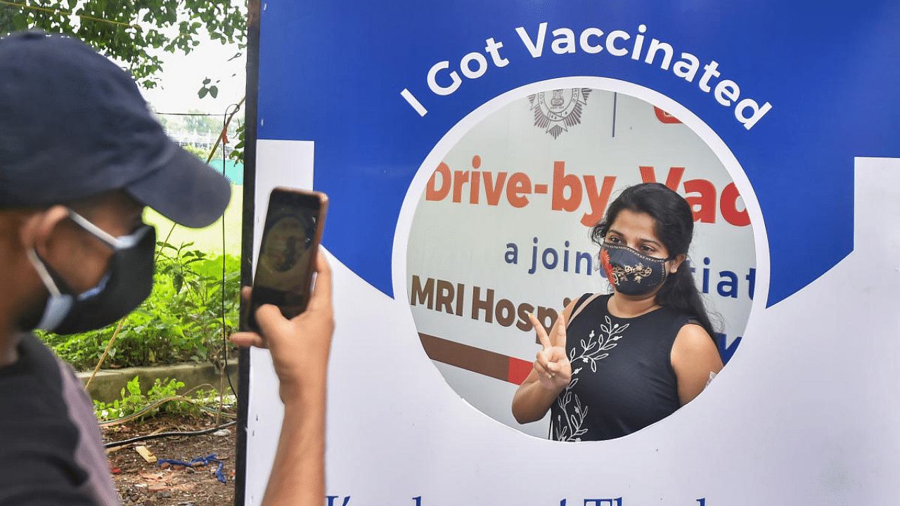 A beneficiary poses for a picture after receiving the Covid-19 vaccine near the East Bengal club, in Kolkata. Credit: PTI Photo