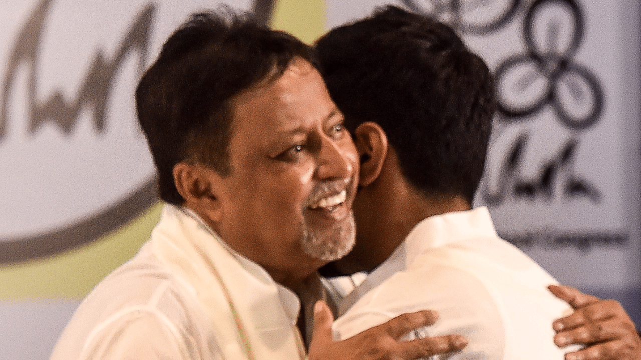 BJP leader Mukul Roy hugs TMC National General Secretary Abhisekh Banerjee during his re-joining of TMC party. Credit: PTI Photo