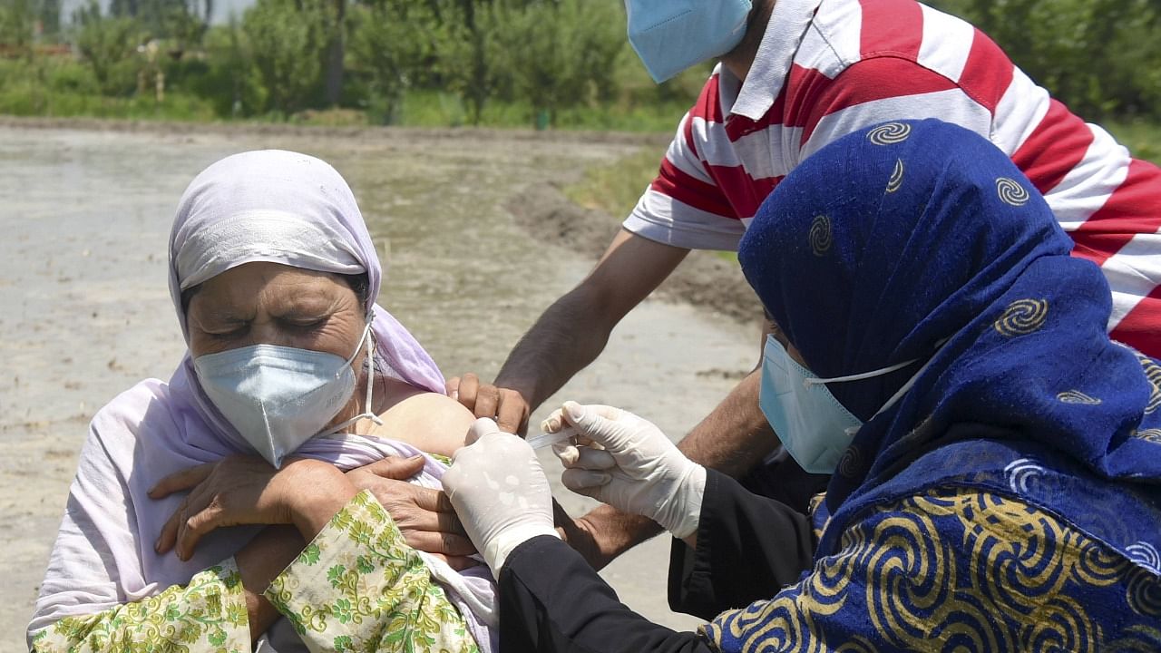 A health worker administers a dose of the Covid-19 vaccine to a woman during a door to door vaccination campaign in J&K. Credit: PTI Photo