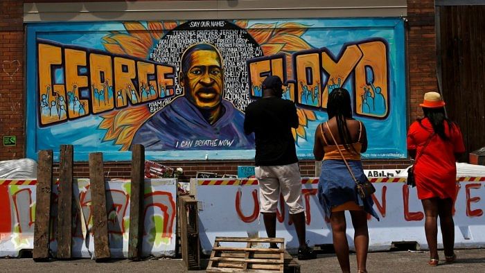 Community members visit one of the murals at George Floyd Square. Credit: Reuters File Photo