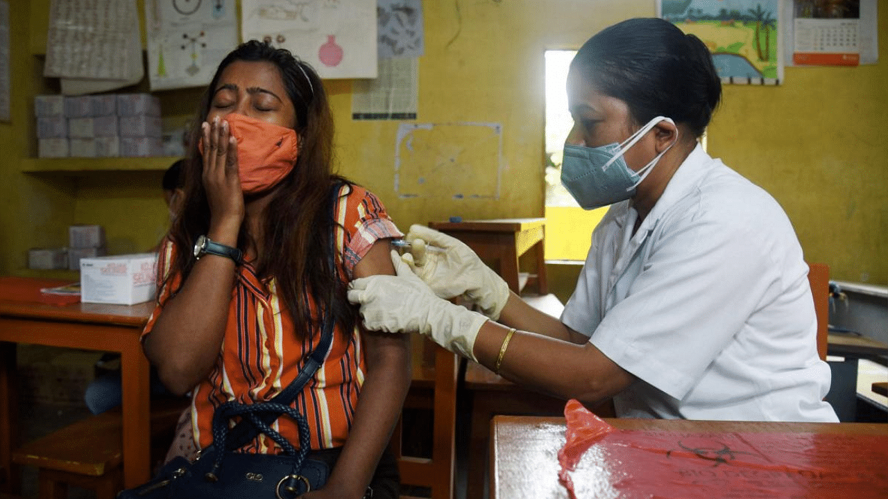 A medic administers a dose of Covid-19 vaccine to a young person at a vaccination centre in Guwahati. Credit: PTI Photo