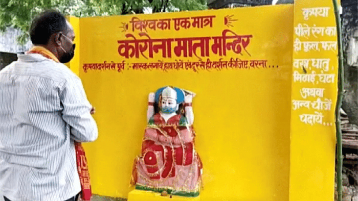 A devotee cheers while standing near an idol of 'Corona Mata' (Mother Corona), at a temple in Pratapgarh, Uttar Pradesh. Credit: Reuters File Photo. 