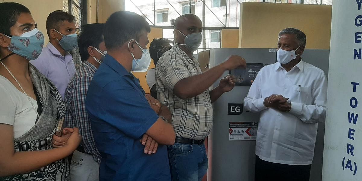 District In-charge Minister V Somanna being briefed by an expert on the working of the oxygen unit.