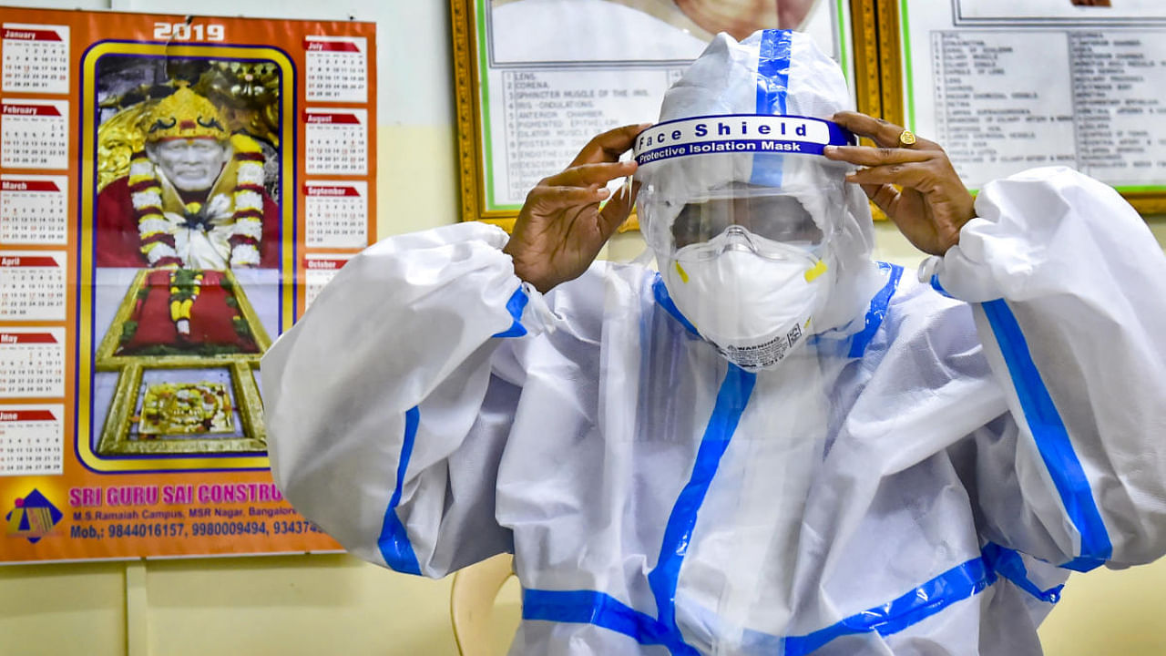 A health worker gets ready for Covid ward duty, at Ramaiah Medical College hospital in Bengaluru. Credit: PTI Photo