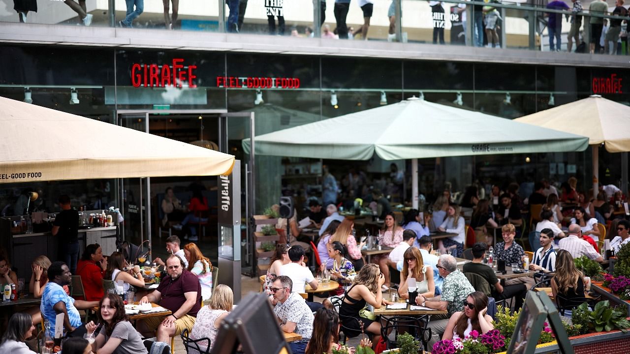 People sit at an outdoor restaurant on the South Bank during sunny weather, amid the coronavirus disease outbreak, in London. Credit: Reuters file photo