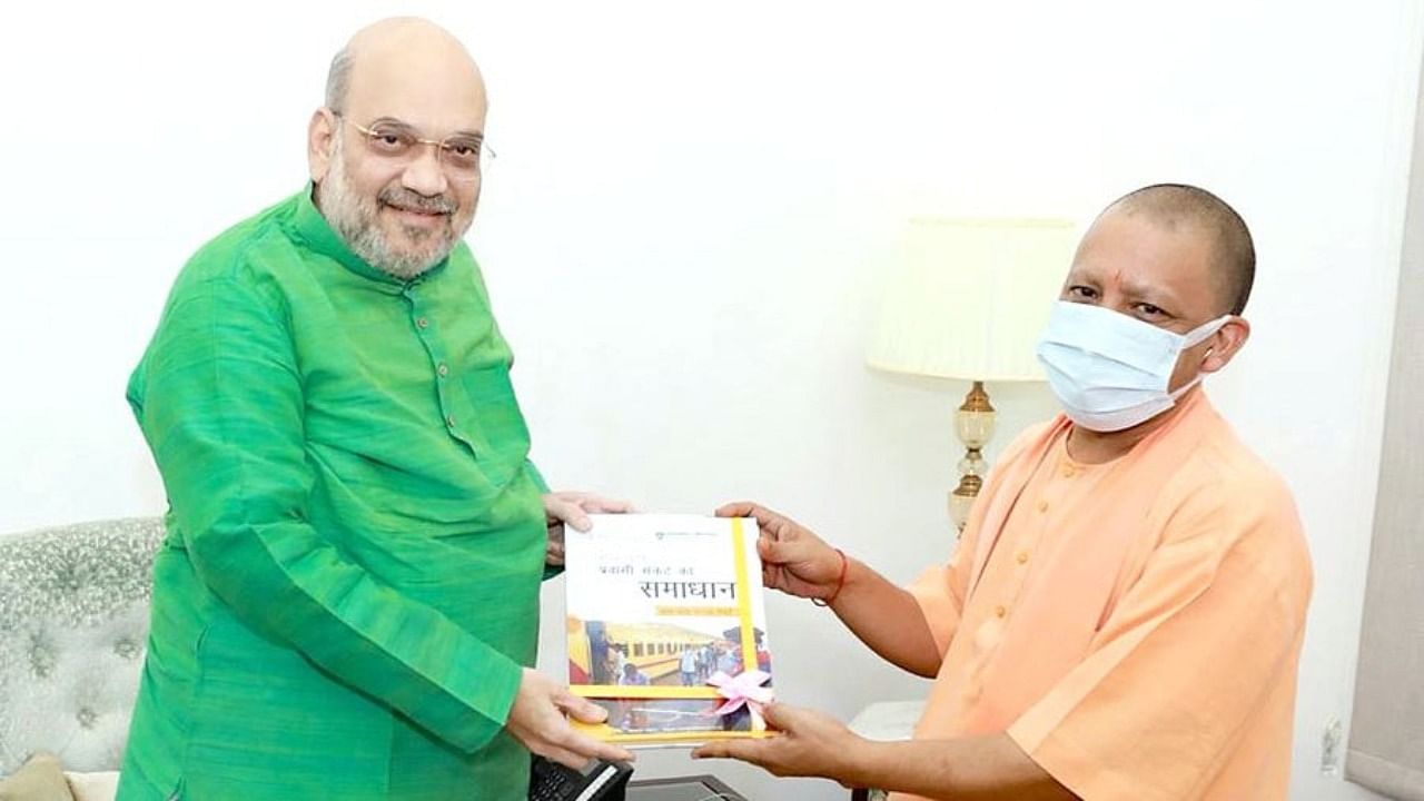 Adityanath handing over a book to Home Minister Amit Shah during the meeting. Credit: Twitter/@myogiadityanath