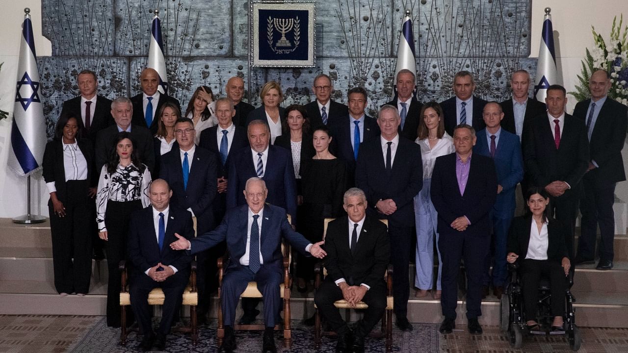 Israeli Prime Minister Naftali Bennett, seated left, President Reuven Rivlin, seated center, and Alternate Prime Minister and Minister of Foreign Affairs Yair Lapid seated right, pose for a group photo with the ministers of the new government at the President's residence in Jerusalem, Monday, June 14, 2021. Credit: AP/PTI Photo
