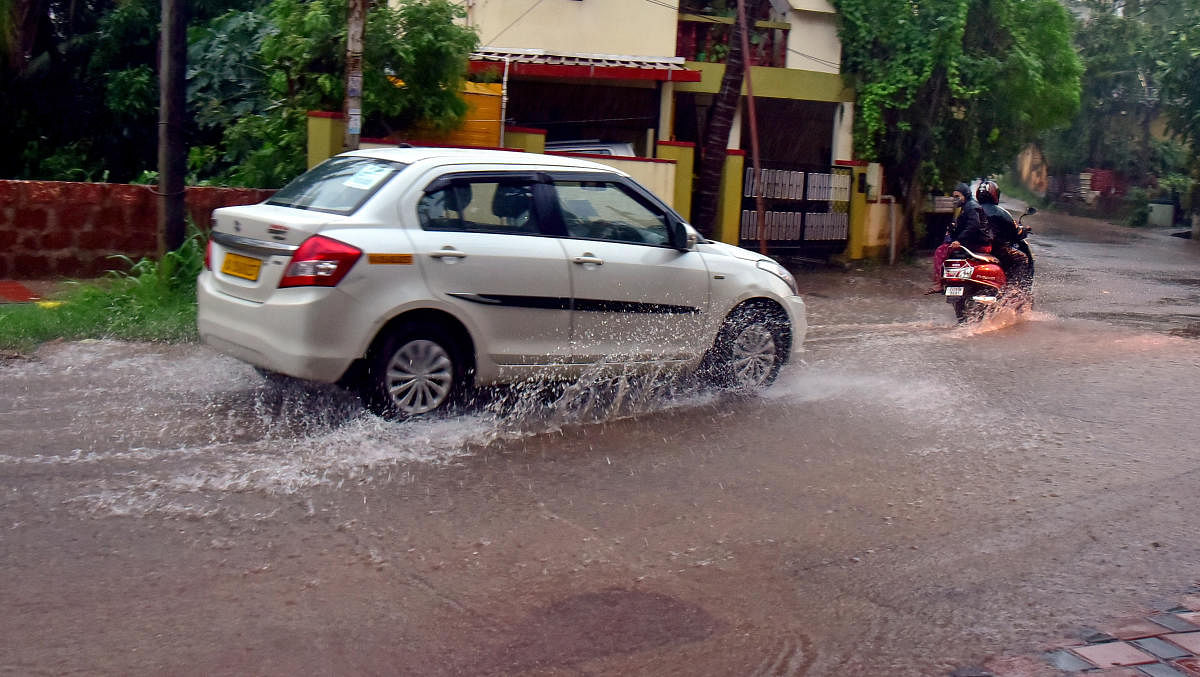 Vehicles wade through water-logged Kadri-Kambala Road in Mangaluru on Sunday. Credit: DH photo/Govindraj Javali