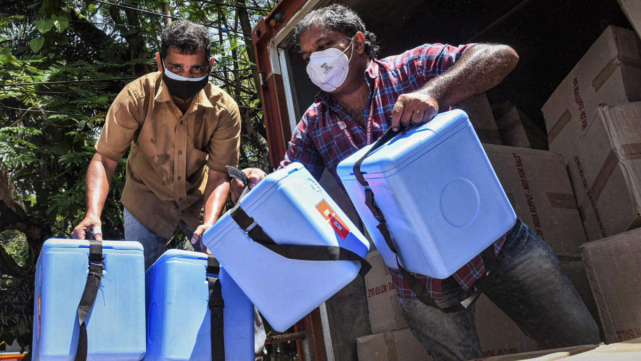 Workers transport the Covid-19 vaccine carrier boxes for distribution to various vaccine centres in Kochi. Credit: PTI Photo