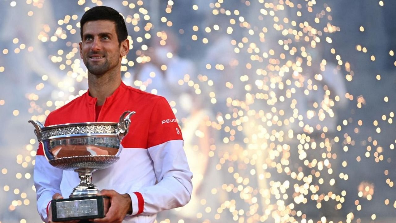 Serbia's Novak Djokovic poses with The Mousquetaires Cup (The Musketeers) after winning against Greece's Stefanos Tsitsipas at the end of their men's final tennis match on Day 15 of The Roland Garros 2021 French Open tennis tournament in Paris on June 13, 2021. Credit: AFP Photo