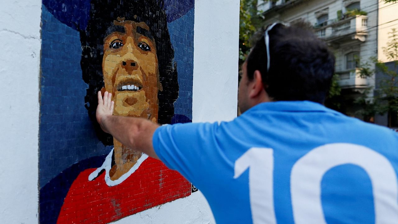 A man touches a mosaic made by the cultural organisation Comando Maradona as a homage to late Argentine soccer superstar Diego Armado Maradona. Credit: Reuters file photo