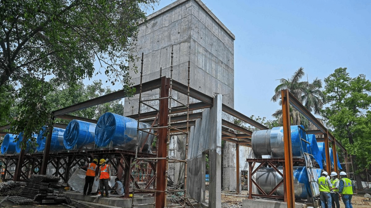 Engineers (R) supervise as the workers are engaged in the construction of the national capital's first smog tower said to be 25 meters in height near Connaught Place in New Delhi. Credit: AFP Photo