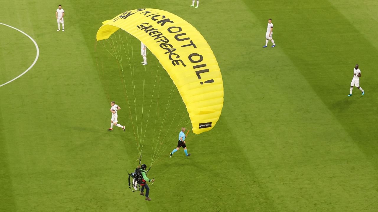 The protestor's parachute had the slogan 'KICK OUT OIL!' and 'Greenpeace' written on it. Credit: Reuters Photo