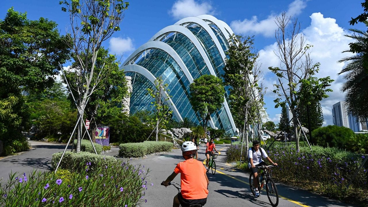 People cycling along a path next to the Flower Dome in the Gardens by the Bay in Singapore. Credit: AFP Photo
