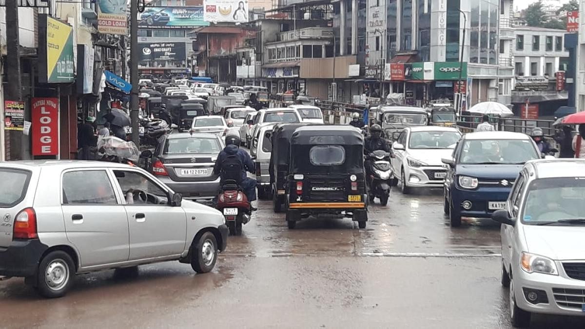 Vehicles move in Madikeri amid rain, on Wednesday.