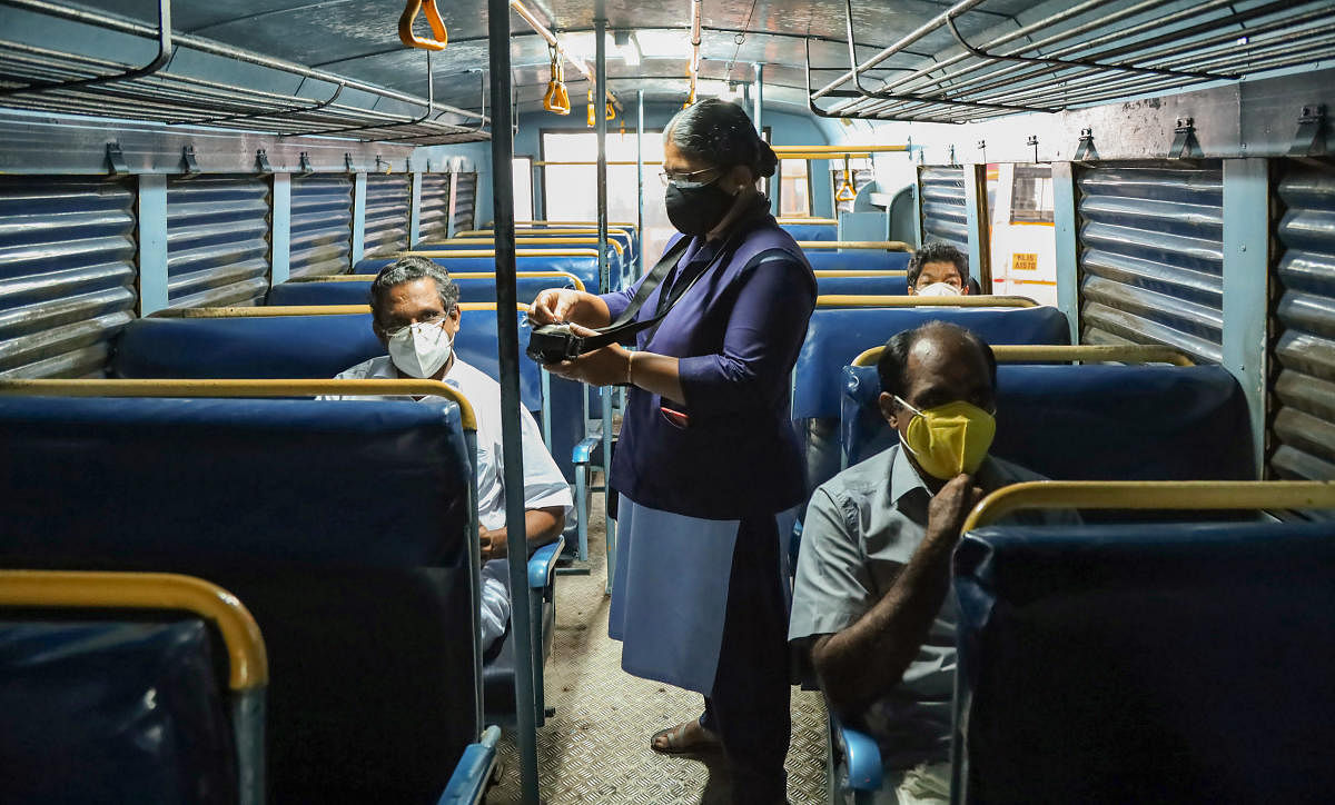 A lady conductor issues tickets to customer during start of Kerala RTC services, after relaxations in Covid-19 lockdown, in Kozhikode. Credit: PTI Photo