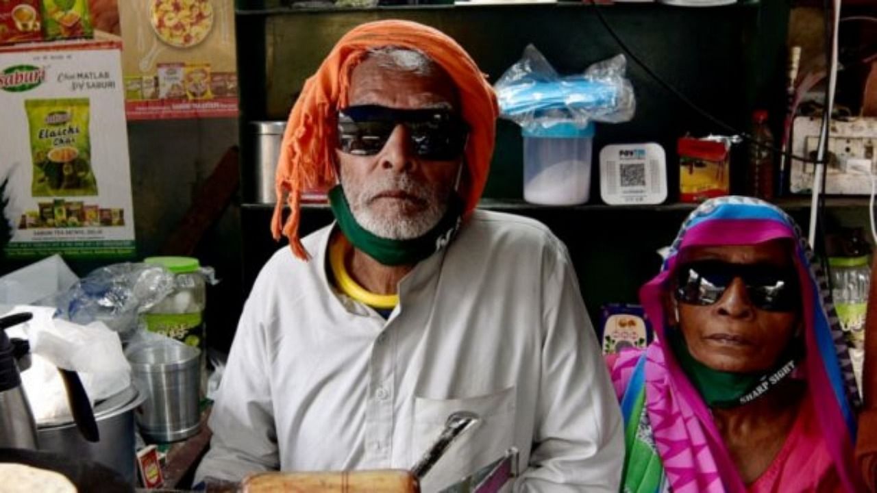 80-year-old Kanta Prasad and Badami Devi serve food at 'Baba Ka Dhaba', nearly a month after its owners' plight became viral on social media and revived their livlihood amid coronavirus pandemic, at Malviya Nagar in New Delhi. Credit: PTI File Photo