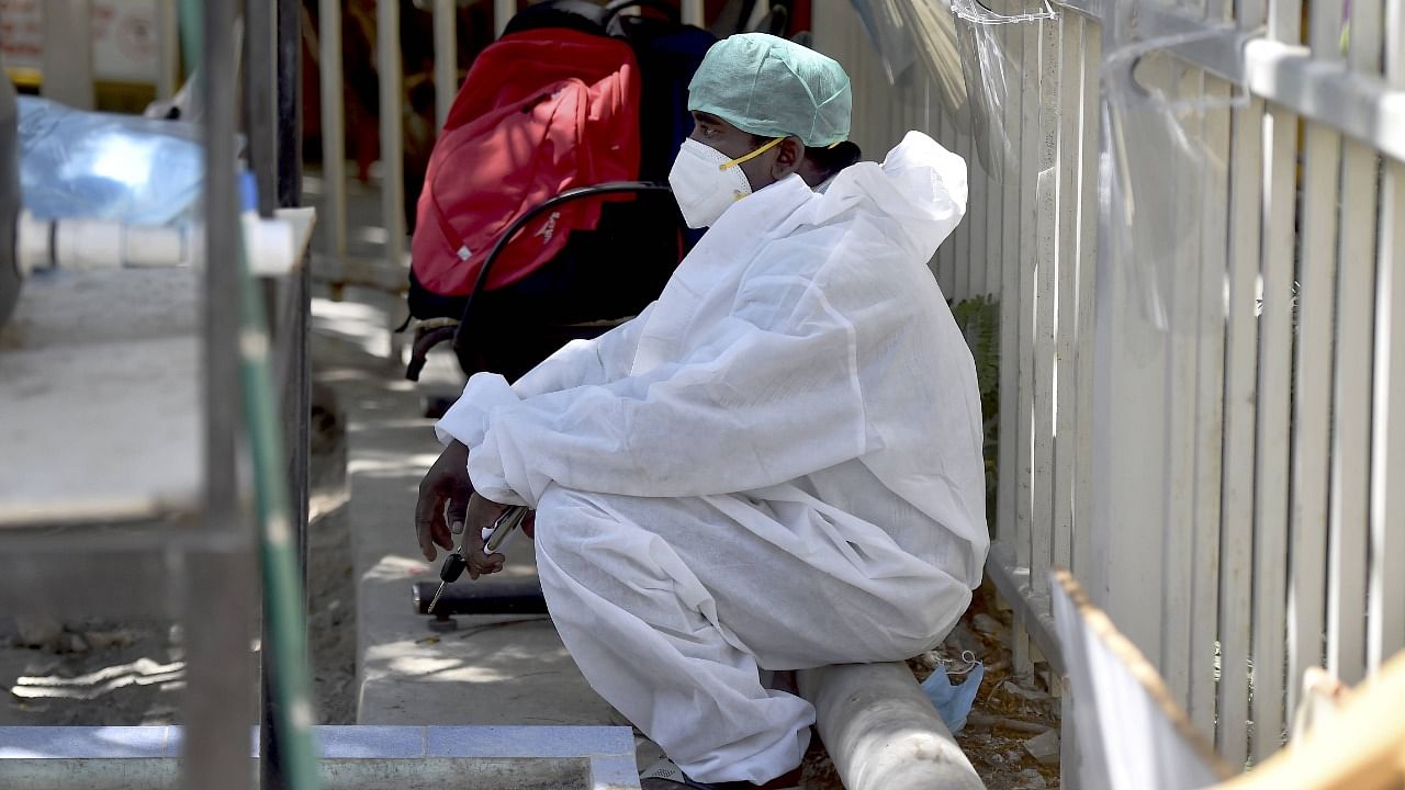 A health worker takes rest outside the Covid Care Centre of Rajiv Gandhi Government General Hospital (RGGGH), in Chennai, Monday, May 10, 2021. Credit: PTI Photo