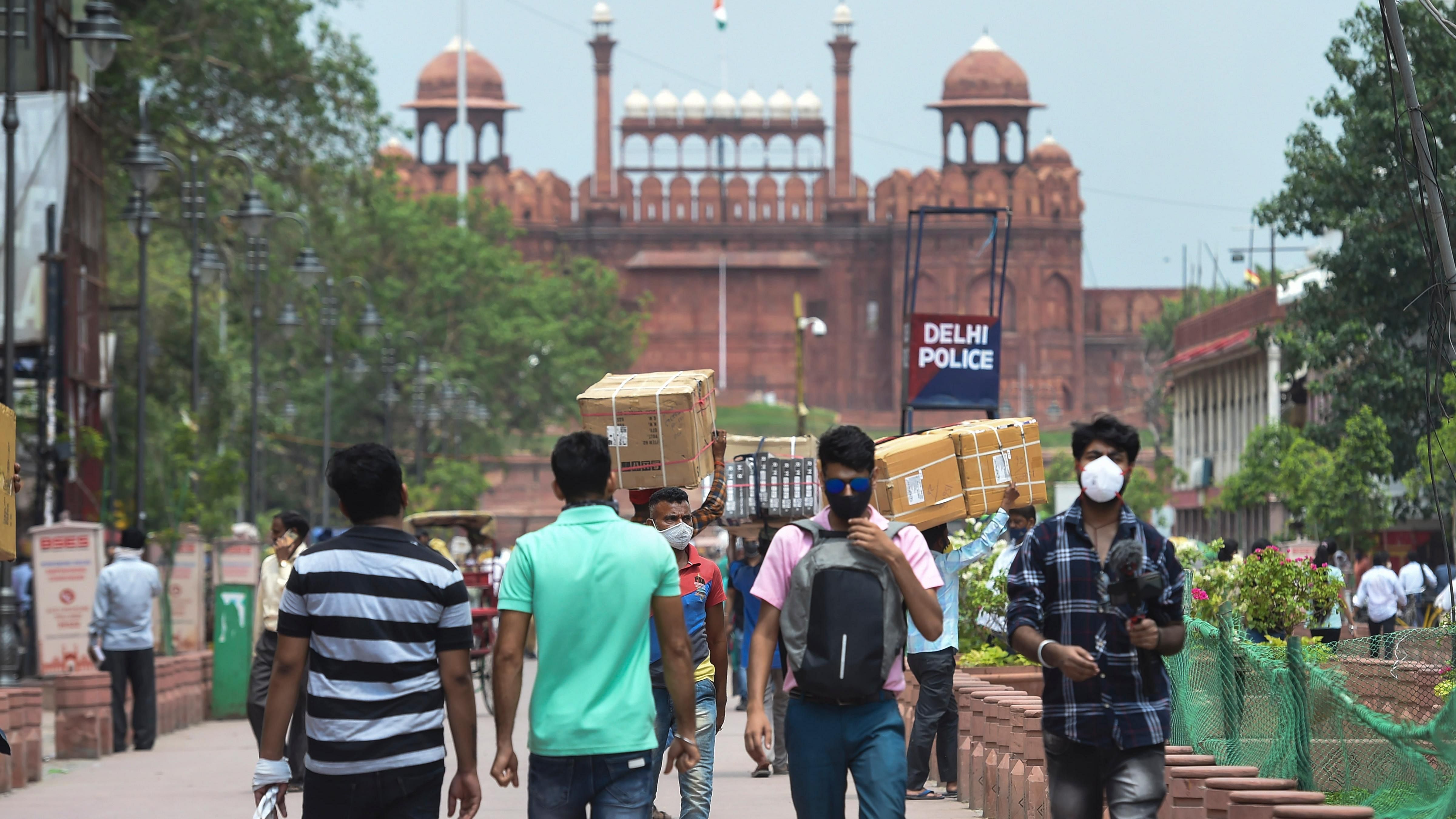 People walk on the Chandni Chowk street facing the Red Fort after Delhi government eased some restrictions in the ongoing Covid-19 induced lockdown, in New Delhi. Credit: PTI File Photo