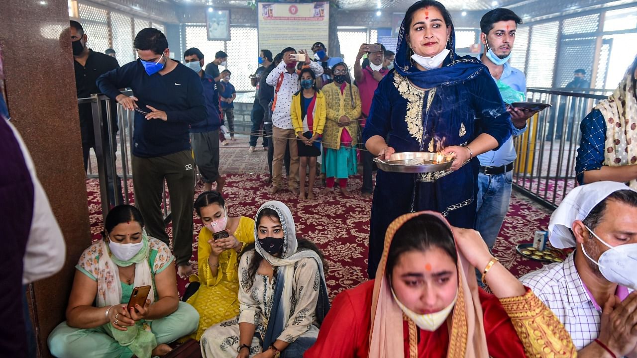 Devotees wait to offer prayers during the annual festival of Kheer Bhawani Temple, amid partial relaxation in the ongoing Covid-19 lockdown, at Tulmula in Ganderbal district, Friday, June 18, 2021. Credit: PTI Photo