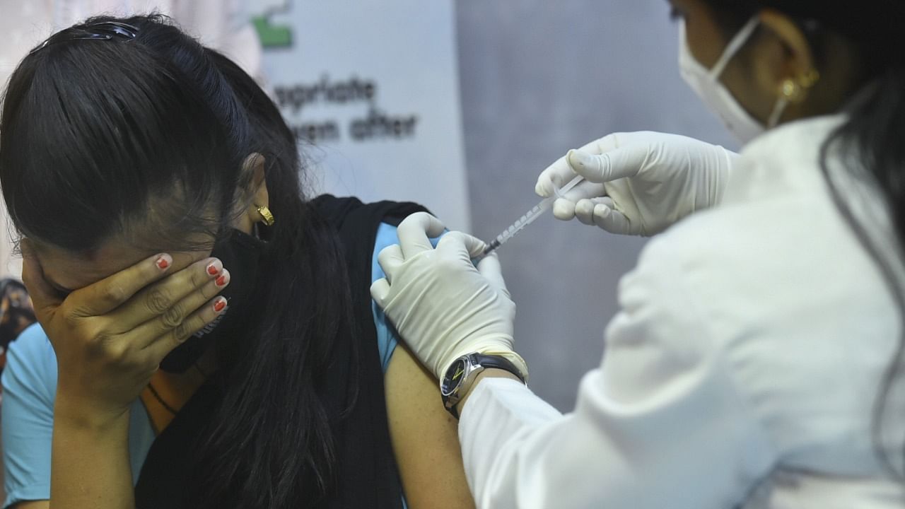 A medic administers a dose of Covid-19 vaccine to a staff of Parliament House, in New Delhi, Friday, June 18, 2021. Credit: PTI Photo