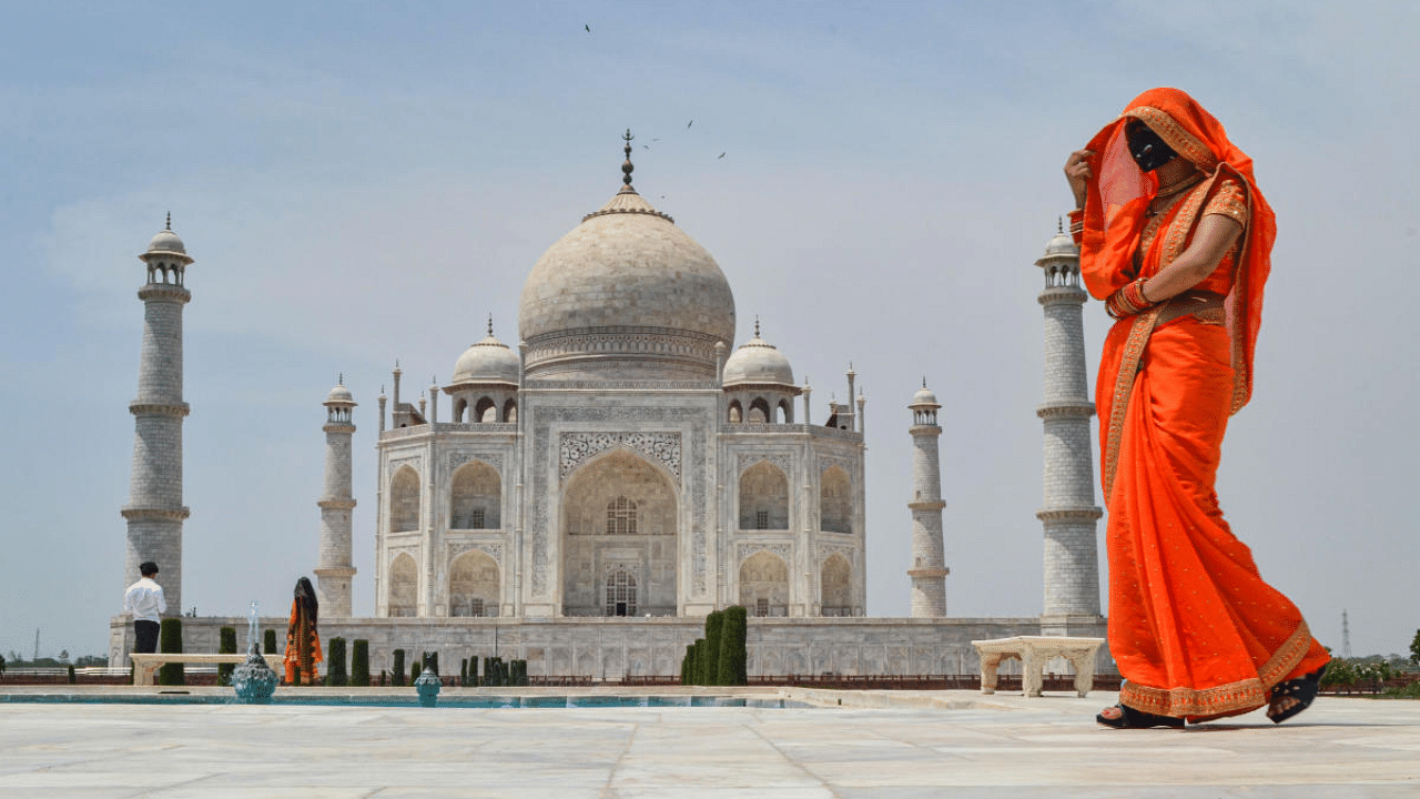  A woman covers her face with her saree to avoid the scorching sunlight, at Taj Mahal in Agra. Credit: PTI Photo