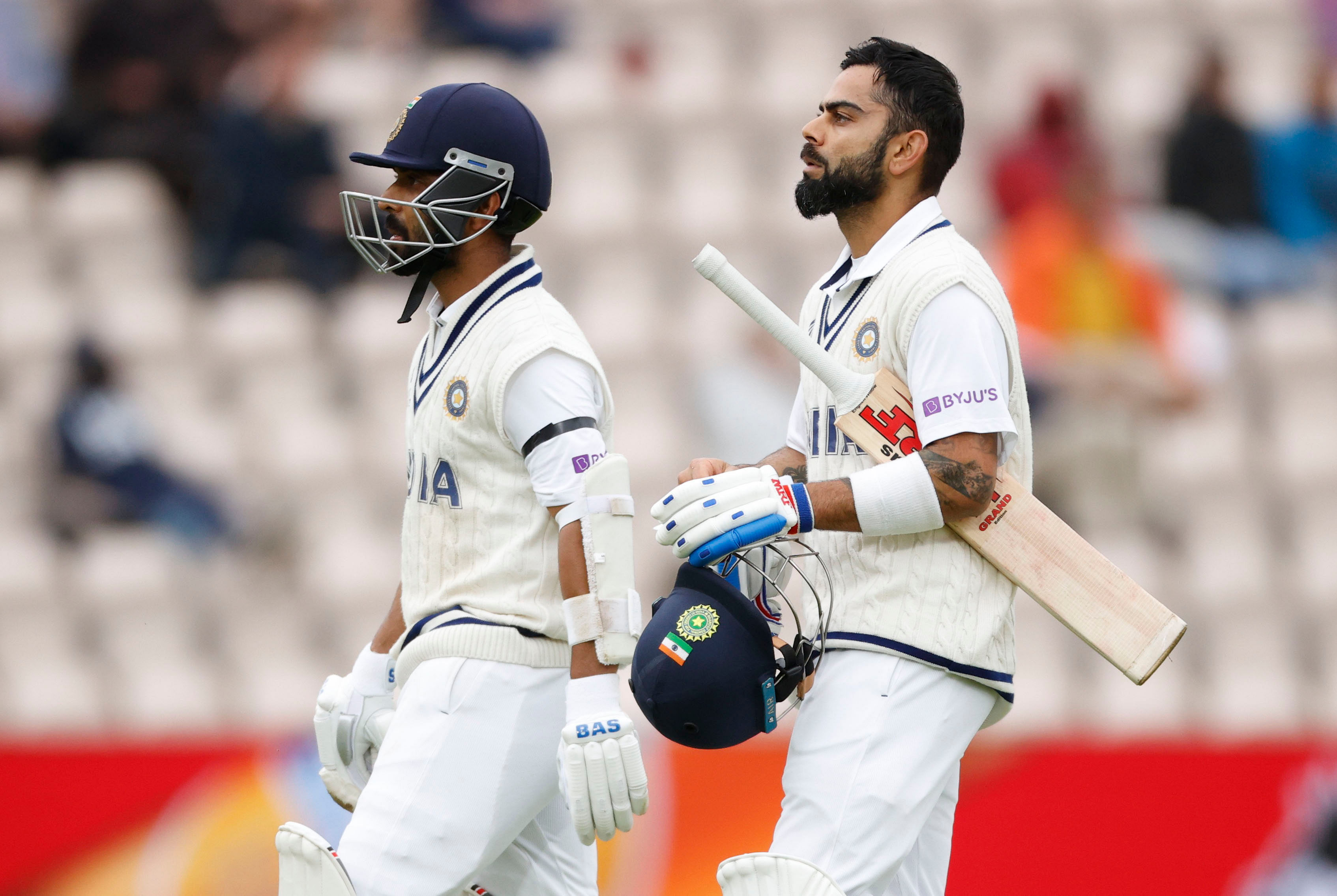 India's Virat Kohli and Ajinkya Rahane walk off the pitch as the game has stopped due to bad lighting. Credit: Reuters Photo