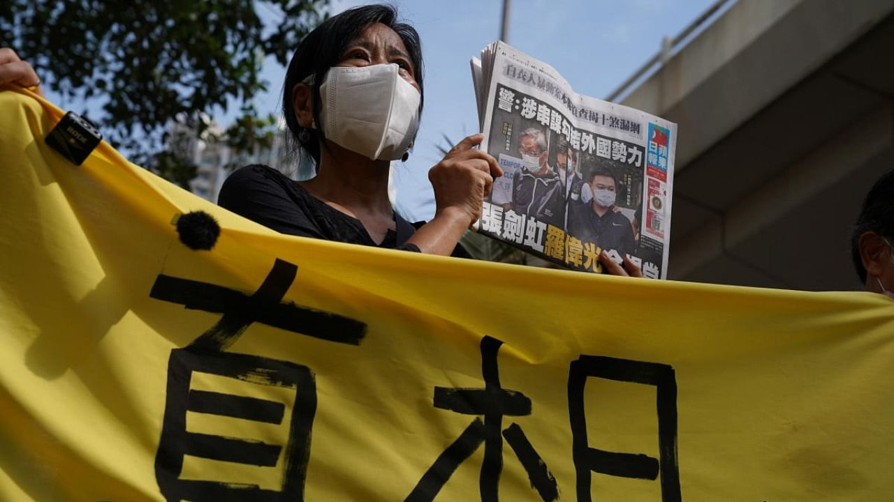 A supporter holds a copy of Apple Daily newspaper during a court hearing outside West Magistrates’ Courts, after police charge two executives of the pro-democracy Apple Daily newspaper over the national security law, in Hong Kong. Credit: Reuters Photo