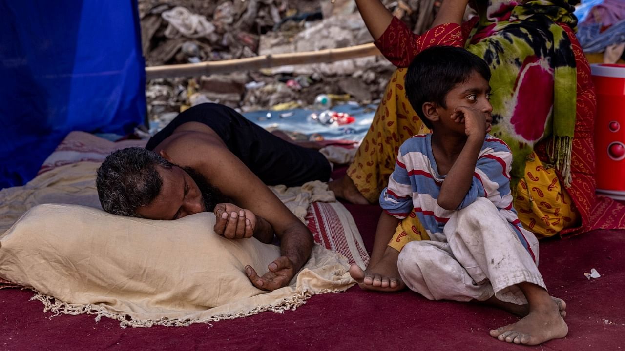 A Rohingya refugee family rests in a temporary shelter. Credit: Reuters File Photo