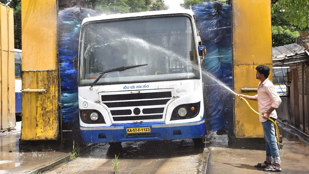 A worker cleans a BMTC bus ahead of the resumption of public transport services in Shantinagar Bus Depot in Bengaluru. Credit: DH Photo/Irshad Mahammad