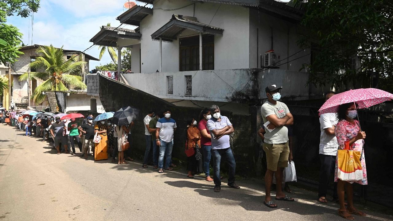 People stand in a queue as they wait to get a dose of the Chinese-made Sinopharm Covid-19 coronavirus vaccine in Colombo on June 15, 2021. Credit: AFP Photo