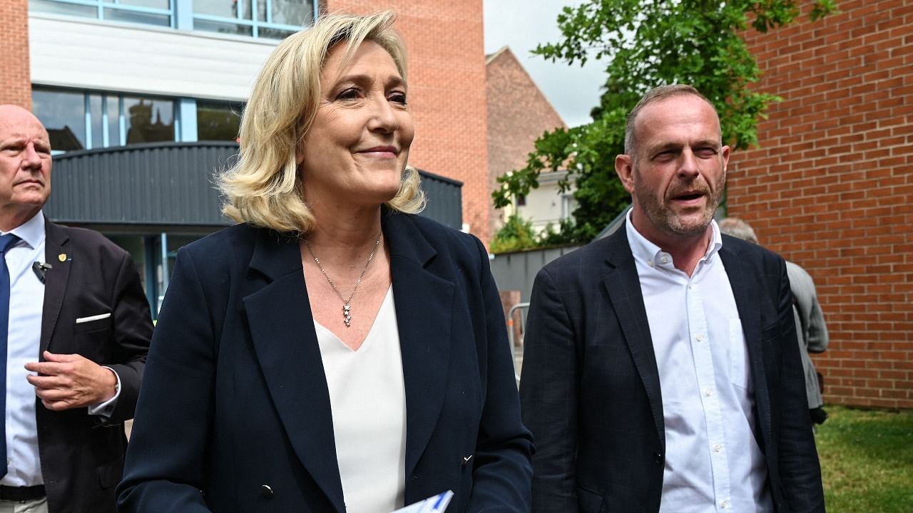 French far-right Rassemblement National (RN) party's leader and member of parliament Marine Le Pen (L) and RN mayor of Henin-Beaumont Steeve Briois (R) leave a polling station in Henin-Beaumont, northern France, for the first round of the French regional elections on June 20, 2021. Credit: AFP Photo