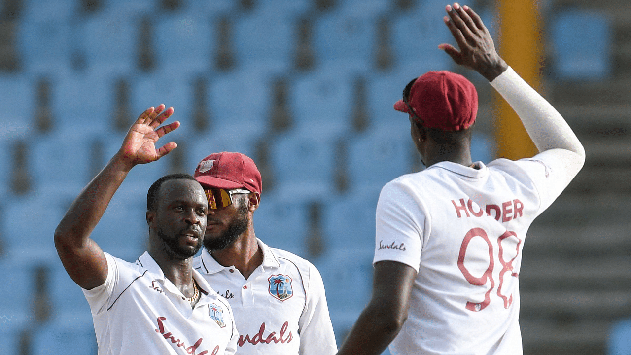 Kemar Roach (L) of West Indies celebrates the dismissal of Anrich Nortje of South Africa during day 3 of the 2nd Test. Credit: AFP Photo