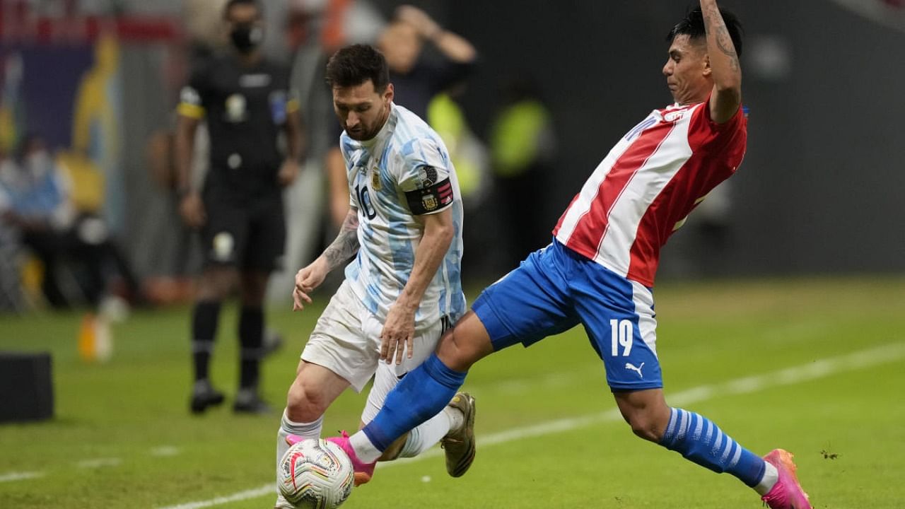 Argentina's Lionel Messi, left, and Paraguay's Santiago Arzamendia battle for the ball during a Copa America soccer match at the National stadium in Brasilia, Brazil. Credit: AP Photo