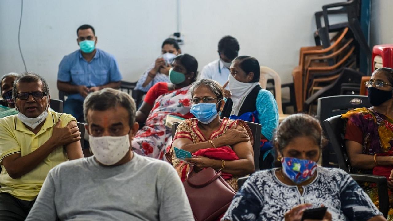 People wait in an observation area after getting inoculated with a dose of the Covishield AstraZeneca-Oxford's Covid-19 coronavirus vaccine at the Rajawadi Hospital in Mumbai. Credit: AFP Photo