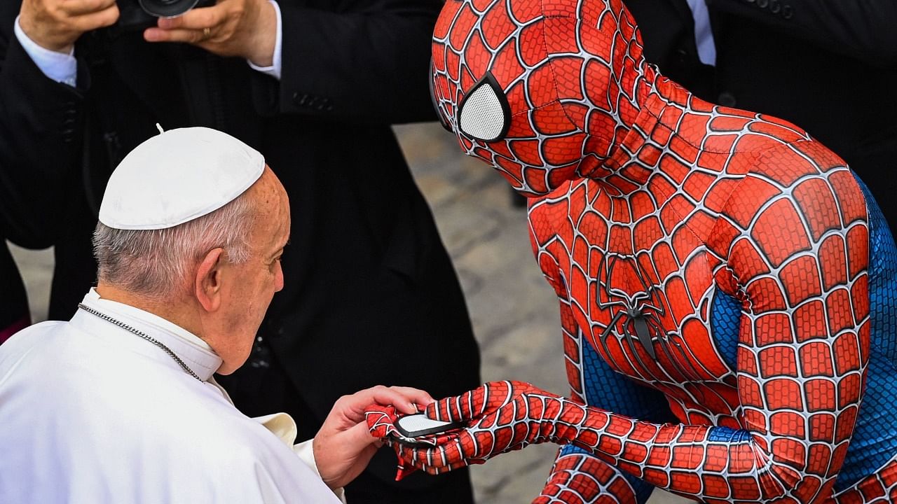 A man wearing a Spider-Man costume hands a Spider-Man mask to Pope Francis as they meet at the end of the weekly general audience at San Damaso courtyard in The Vatican. Credit: AFP Photo