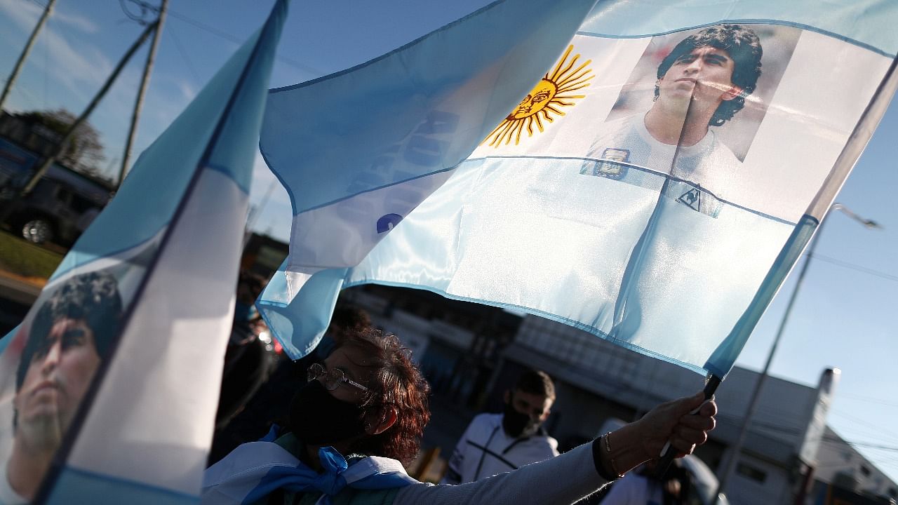 A fan of Argentine soccer superstar Diego Armado Maradona waves a flag depicting him as she celebrates the idol's 35th anniversary of the "goal of the century", against England during the 1986 World Cup played in Mexico, in Buenos Aires. Credit: Reuters photo