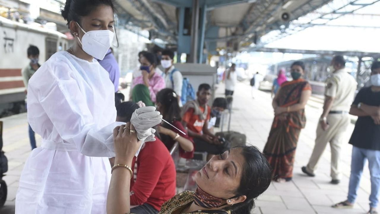A BMC health worker collects swab sample of a passenger for Covid-19 testing, at Dadar railway station in Mumbai, Tuesday, June 22, 2021. Credit: PTI Photo