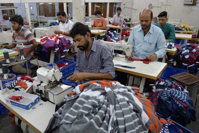 Indian men work at a garment factory in Ludhiana. Credit: AFP File Photo