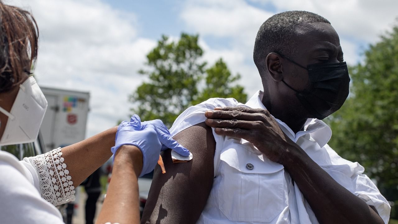 Registered Nurse Dorothy Austin distributes a coronavirus disease (COVID-19) vaccine to a Detroit resident at a mobile vaccination clinic led by Central City Integrated Health in Detroit, Michigan. Credit: Reuters photo