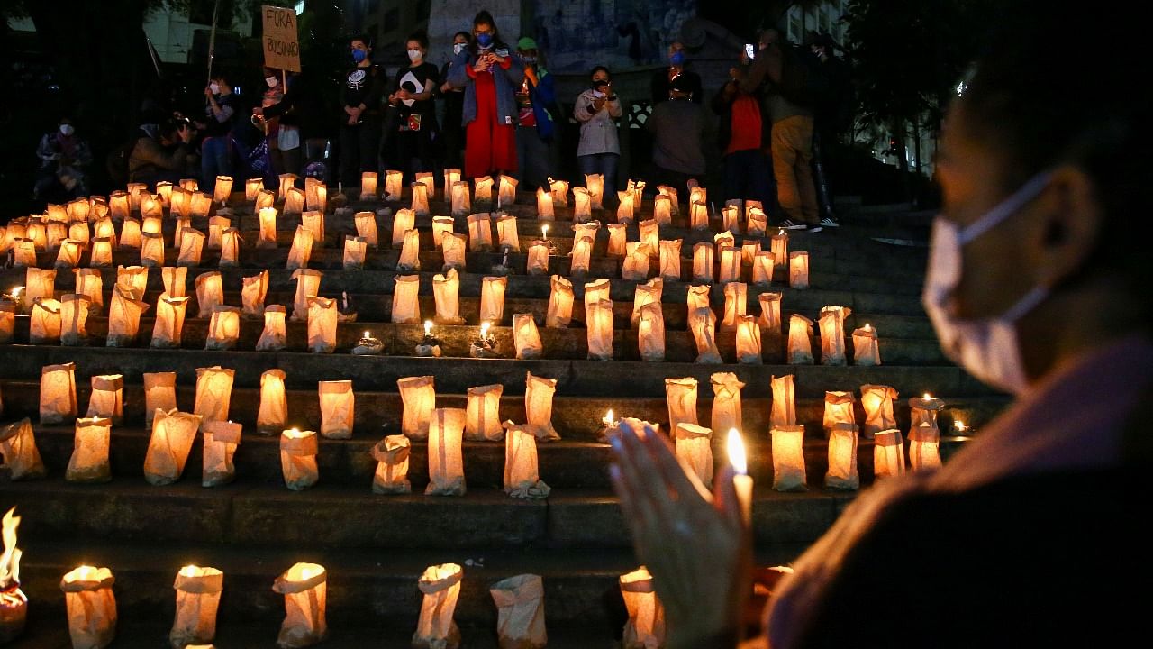 People take part in an event to light candles in honour of the 500,000 people who have died from Covid-19 in Brazil, at the Largo da Memoria, in Sao Paulo. Credit: Reuters photo