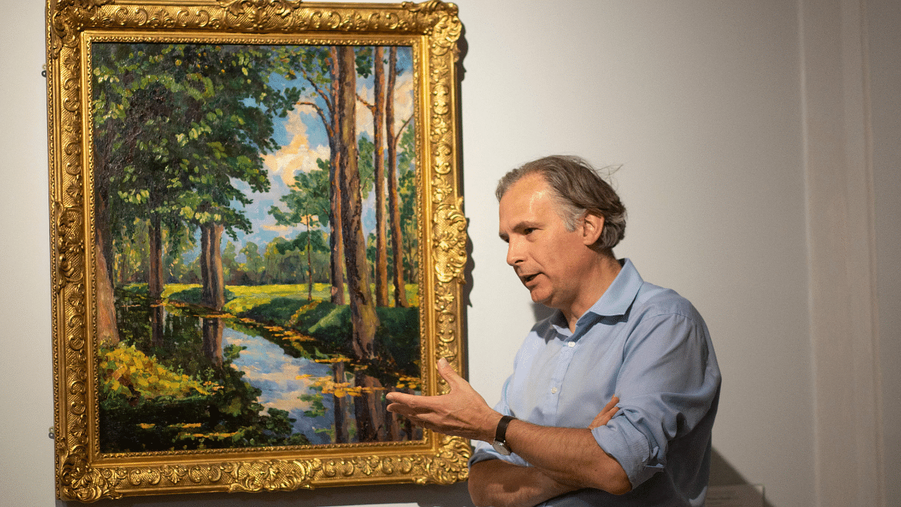 Jean Paul Engelen, Deputy Chairman and worldwide co-head of 20th century and contemporary art at Phillips Auction House speaks next to "The Moat, Breccles" painting made by Winston Churchill. Credit: AFP Photo