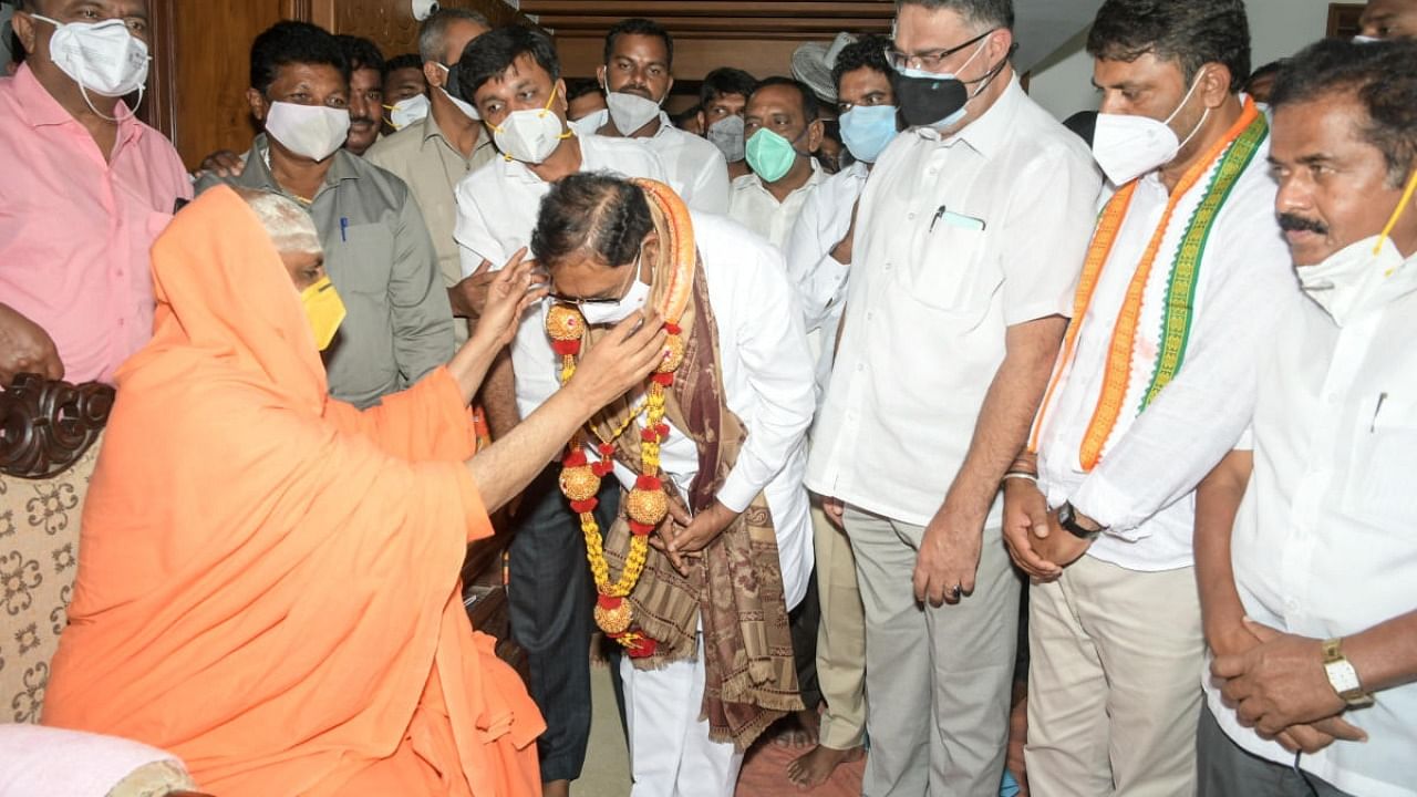 MLA and senior Congress leader G Parameshwara seeks blessings of Suttur seer Shivarathri Deshikendra Swami at Suttur mutt's branch in Mysuru on Thursday. MLA Tanveer Sait and former MLA M K Somashekar are seen. Credit: DH Photo