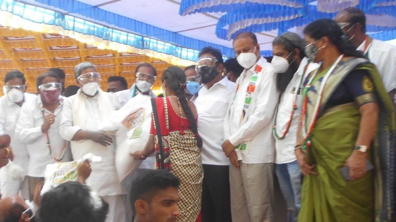 Opposition party leader Siddaramaiah distributes food kits to Covid-19 warriors at K R Pet in Mandya district on Wednesday. Credit: DH Photo