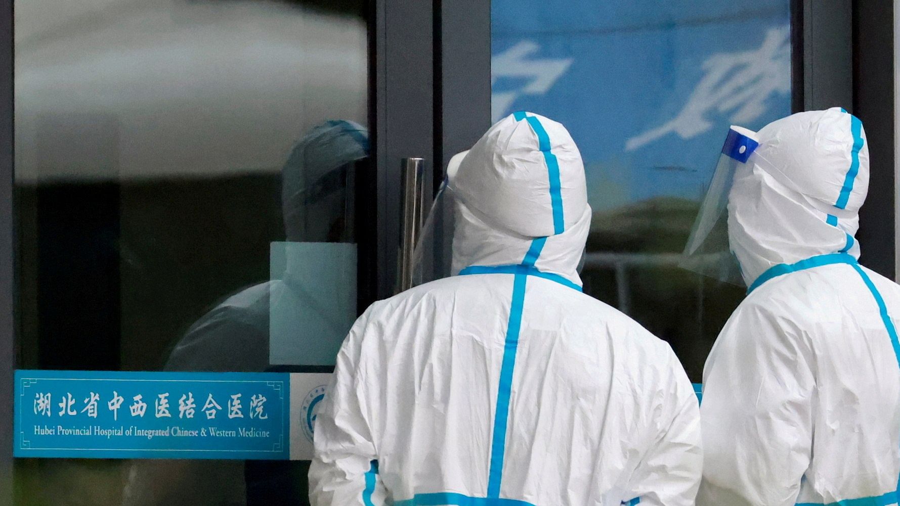 Staff members in protective suits stand at Hubei Provincial Hospital of Integrated Chinese and Western Medicine where members of the World Health Organization (WHO) team tasked with investigating the origins of the coronavirus disease (COVID-19) are visiting, in Wuhan. Credit: reuters File Photo