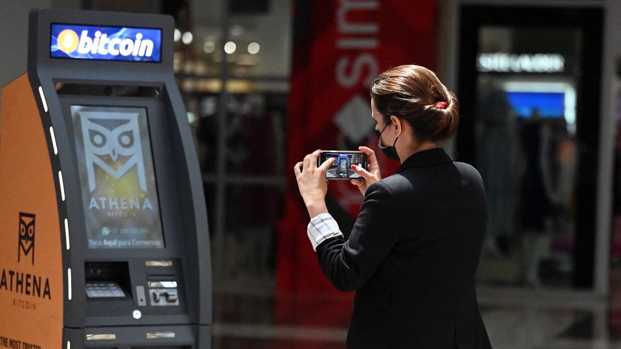 A woman takes a picture of a Bitcoin ATM, after its inauguration by Athena Bitcoin Inc. at a shopping mall in San Salvador. Credit: AFP Photo