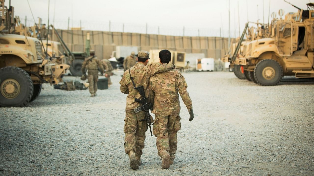 A US soldier from the 3rd Cavalry Regiment walks with the unit's Afghan interpreter before a mission near forward operating base Gamberi in the Laghman province of Afghanistan. Credit: Reuters file photo