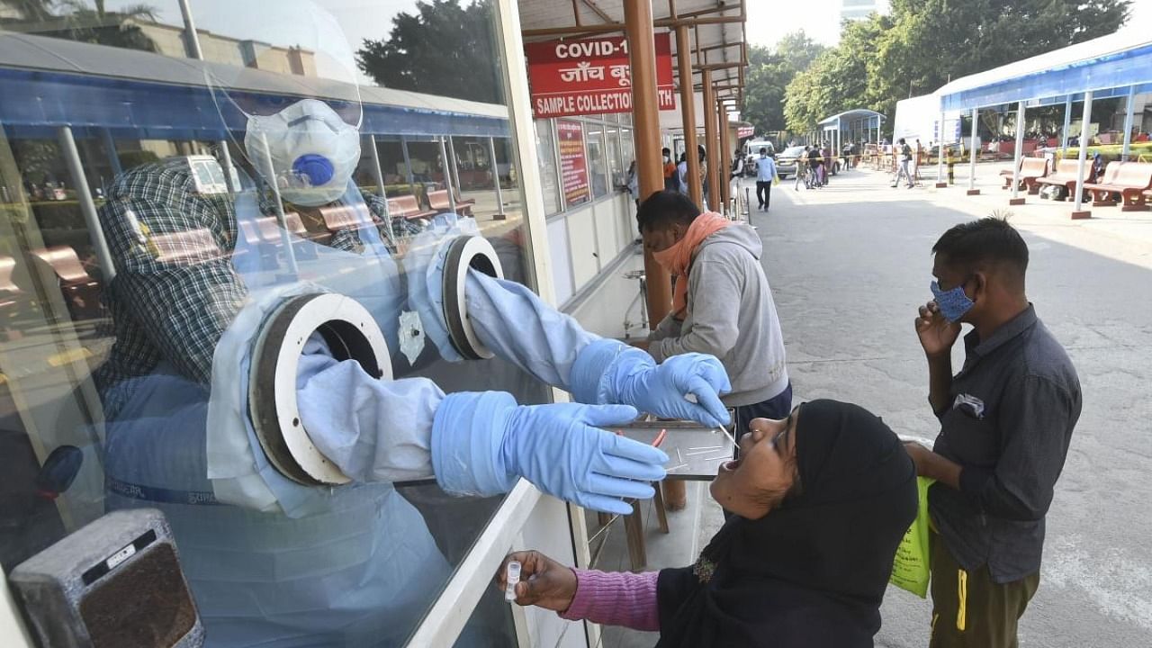 A health worker takes samples for Covid-19 testing at Ram Manohar Lohia Hospital, in Lucknow. Credit: PTI Photo
