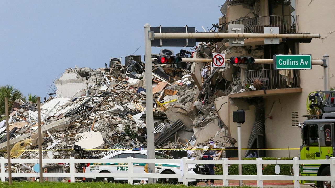 A police car is parked in front of debris from a partially collapsed building in Surfside north of Miami Beach. Credit: AFP Photo