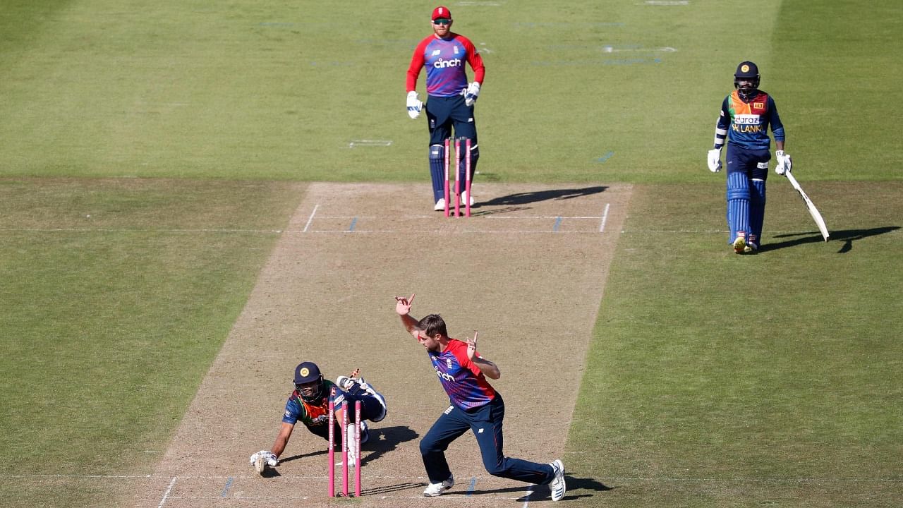 Sri Lanka's Dasun Shanaka (L) loses his wicket as England's Chris Woakes looks on during the third T20I between England and Sri Lanka at The Ageas Bowl in Southampton, south England on June 26, 2021. Credit: AFP Photo